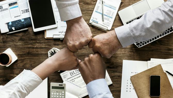 team members putting hands together in a circle