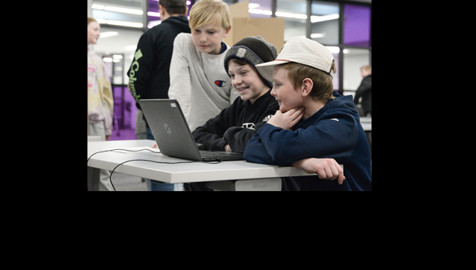 Students look at laptop