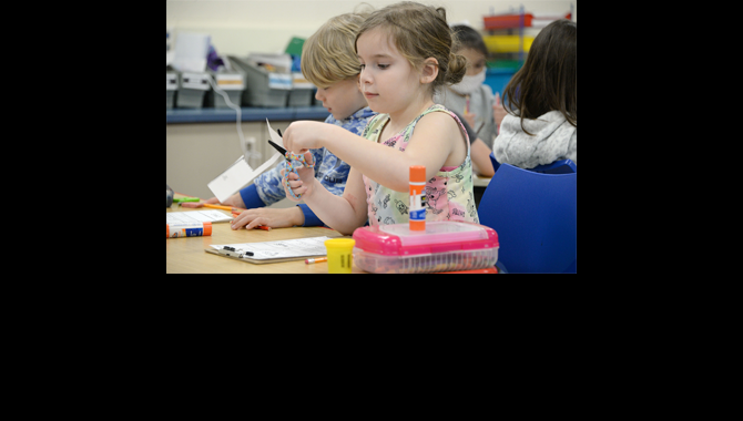 Student cutting paper with scissors