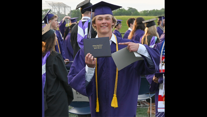 Graduate points to diploma