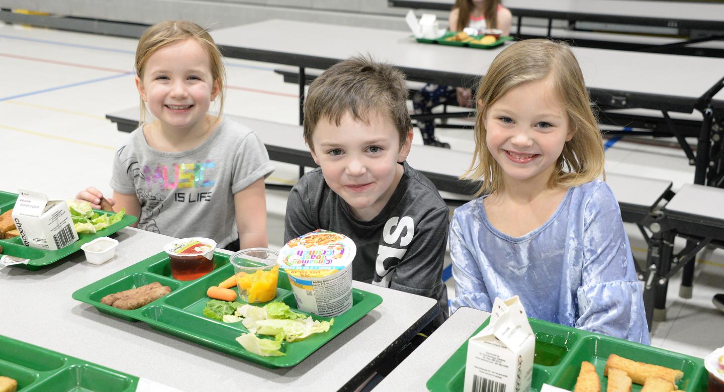 Students smiling at lunch table